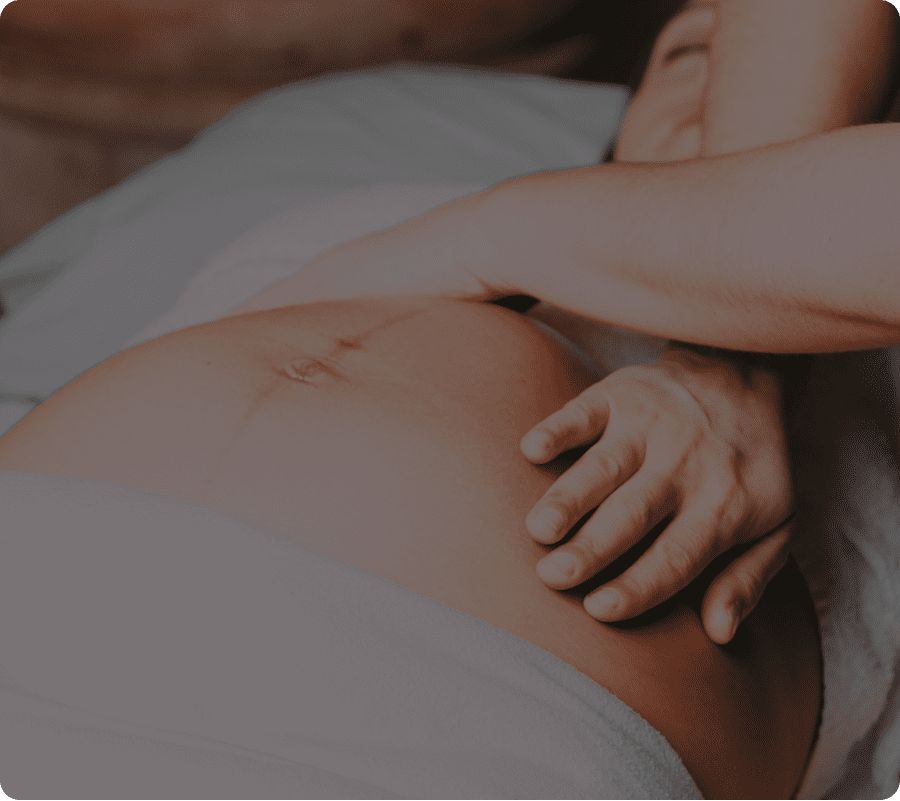 Pregnant belly with hand resting gently.